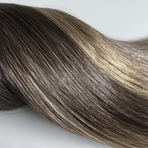 A product photo of Genius Wefts hair extensions in deep noir black, highlighting their shine and smooth, sleek strands.