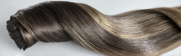 A product photo of Genius Wefts hair extensions in deep noir black, highlighting their shine and smooth, sleek strands.